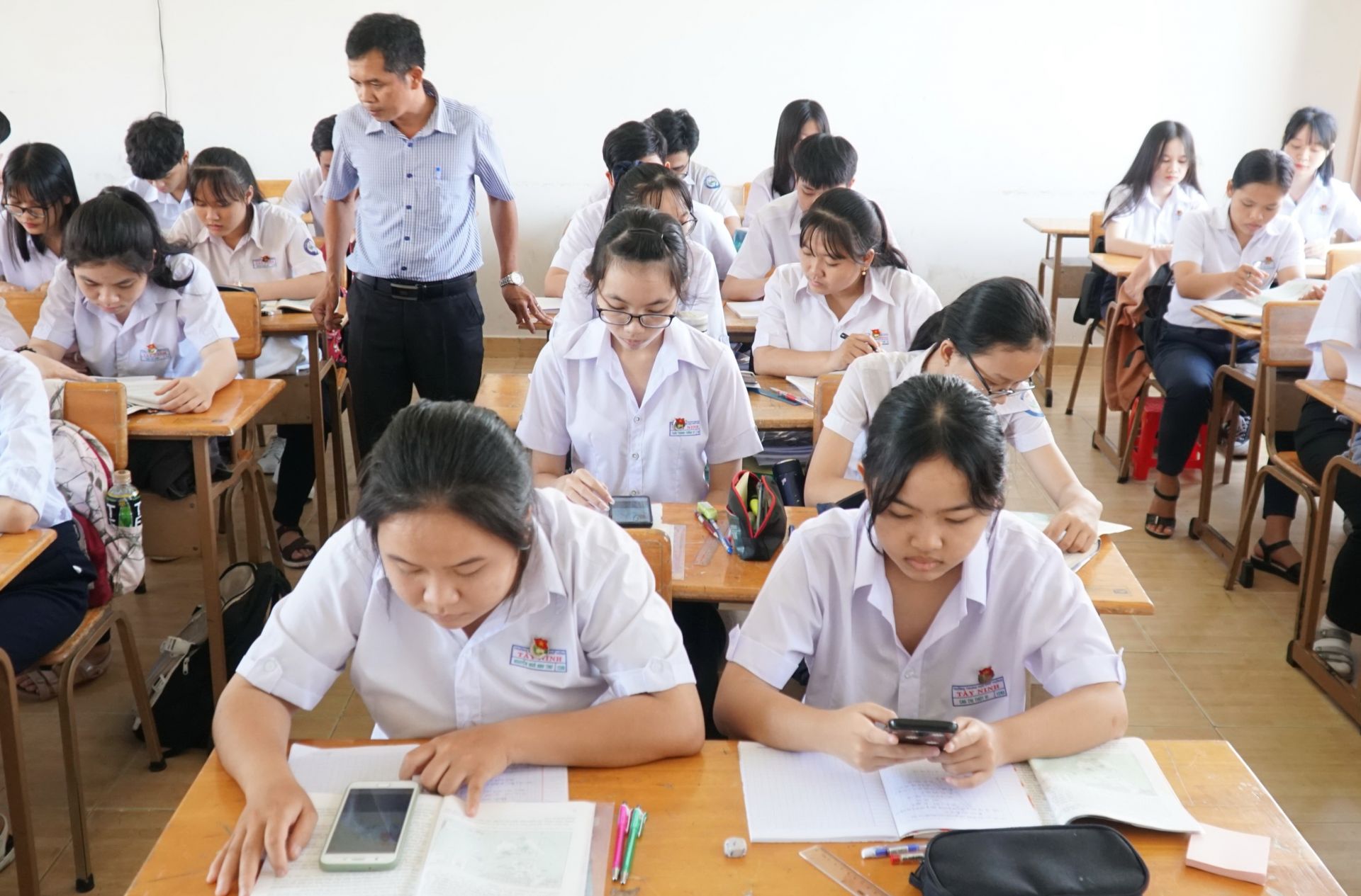 Học sinh sử dụng điện thoại trong lớp