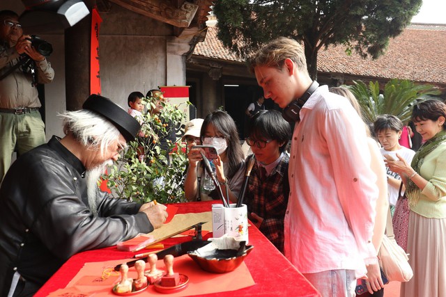 Khách quốc tế trải nghiệm 'Tết làng Việt' tại Làng cổ Đường Lâm- Ảnh 1.